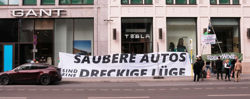 ROBIN WOOD-Aktivist*innen protestieren vor dem Tesla-Store in Berlin-Mitte, 10.05.2024 (Foto: ROBIN WOOD) Protestbanner vor Tesla-Store in Berlin-Mitte