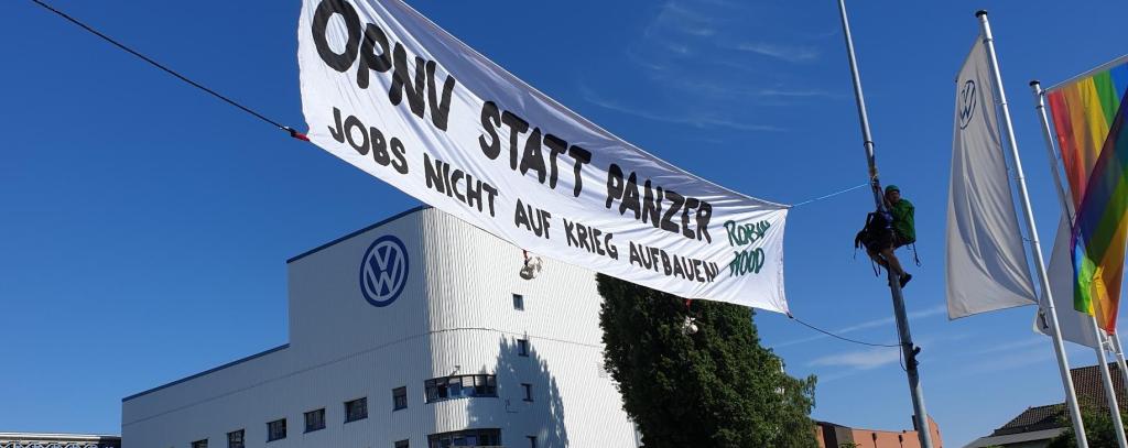 Protestbanner zwischen Laternen vor VW-Werk