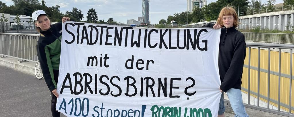 2 Aktive mit Protestbanner gegen A100