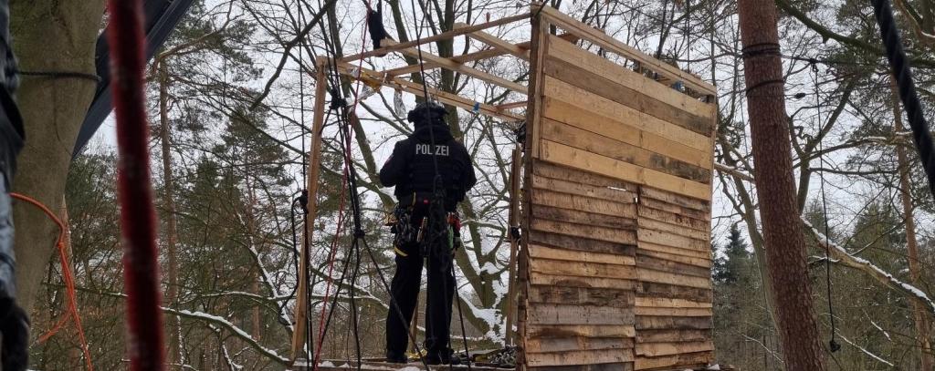 Polizist räumt ein Baumhaus