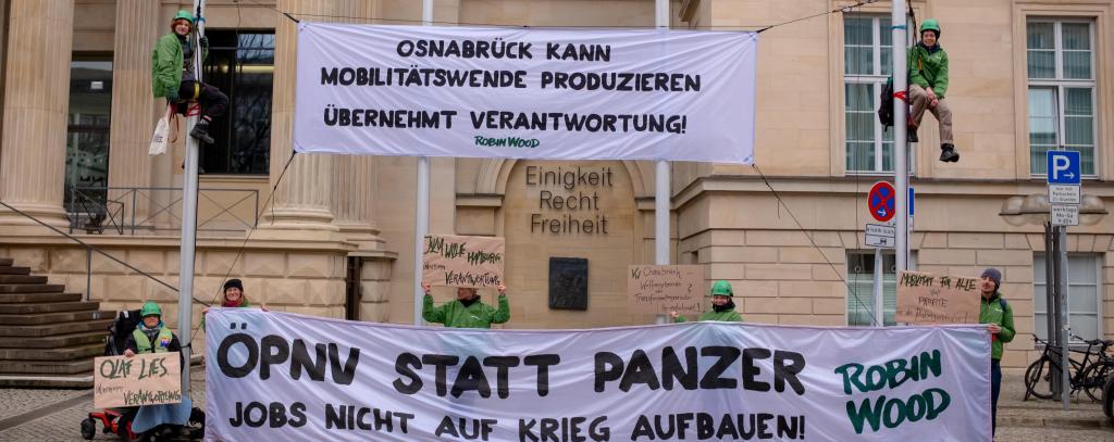 Kletter-Aktive und 2 Protestbanner an Masten vor dem Landtag in Hannover