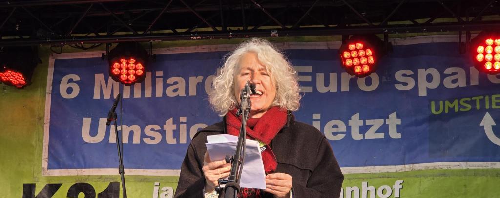 Rednerin mit Mikro auf einer Bühne