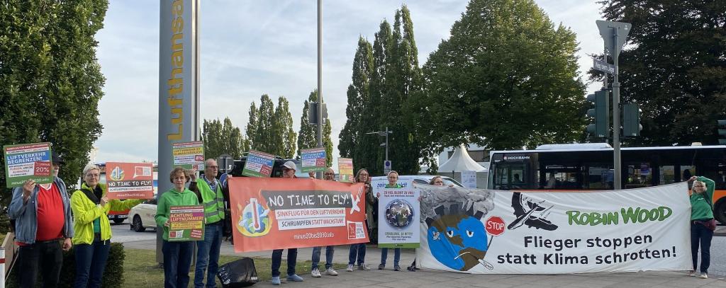 Kundgebung bei der Nationalen Luftfahrtkonferenz 2023 in Hamburg (Foto: ROBIN WOOD) "Flieger stoppen statt Klima schrotten" - Protestierende mit Bannern