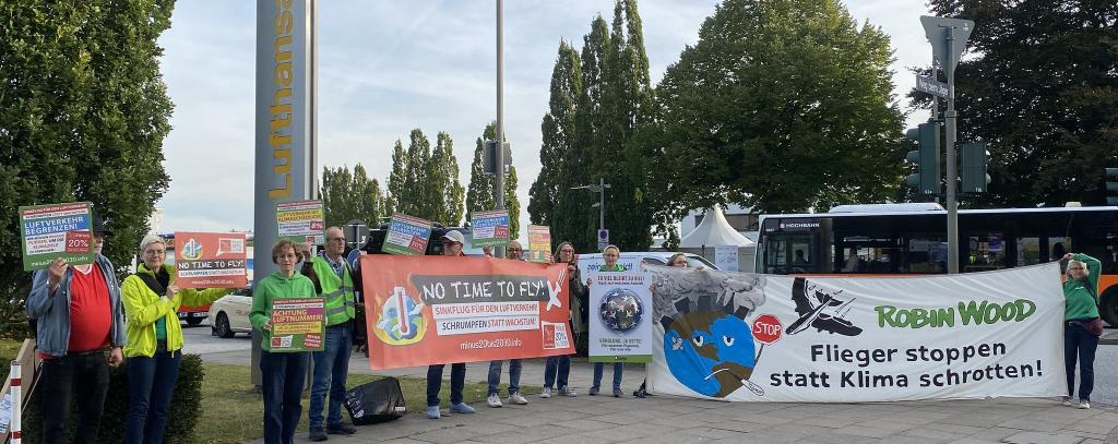 Klima-Protest bei der Nationalen Luftfahrtkonferenz am Flughafen Hamburg, 25.09.2023 (Foto: BUND HH) Klima-Aktivist*innen mit Protestbannern vor der Lufthansa-Basis in Hamburg