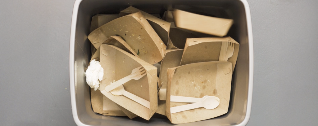 Mülltonne mit Einwegverpackungen von Essen
