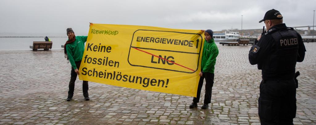 ROBIN WOOD-Protest gegen Flüssigerdgas und für eine klimagerechte Energiewende (Foto: ROBIN WOOD/Moritz Heck) 2 Aktivist*innen halten gelbes Protestbanner gegen LNG