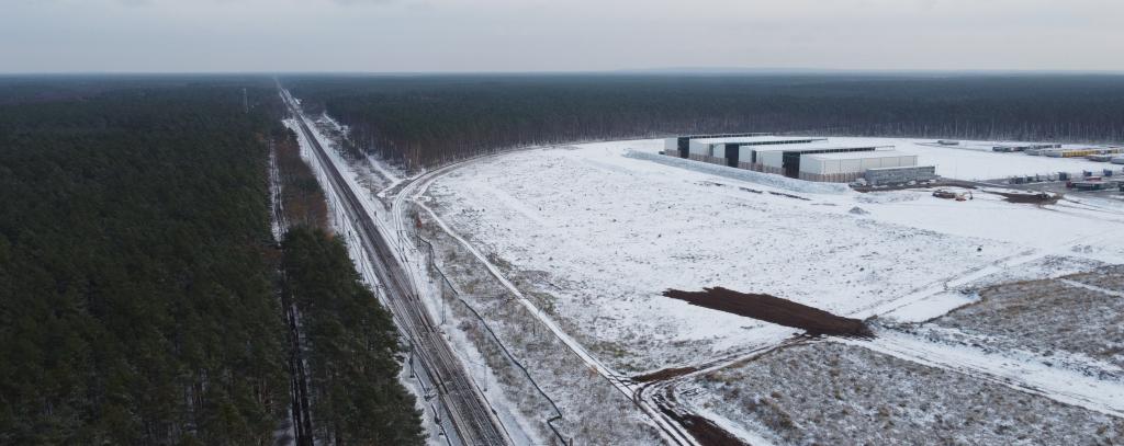 Freifläche in einem Wald, Logistikgebäude, Schienenstrecke