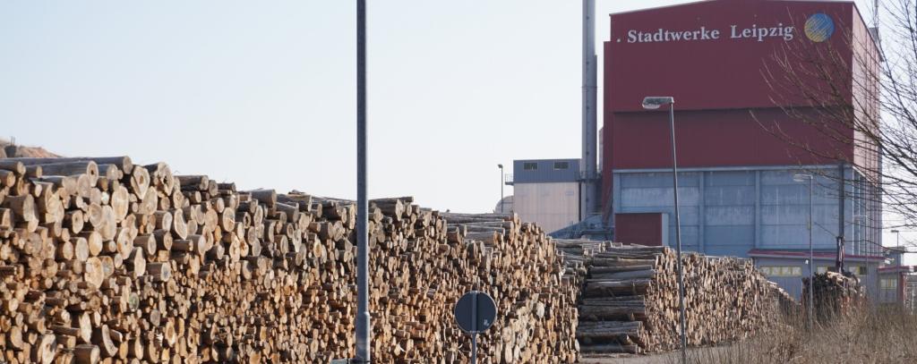 Holzpolter vor Kraftwerksgebäude