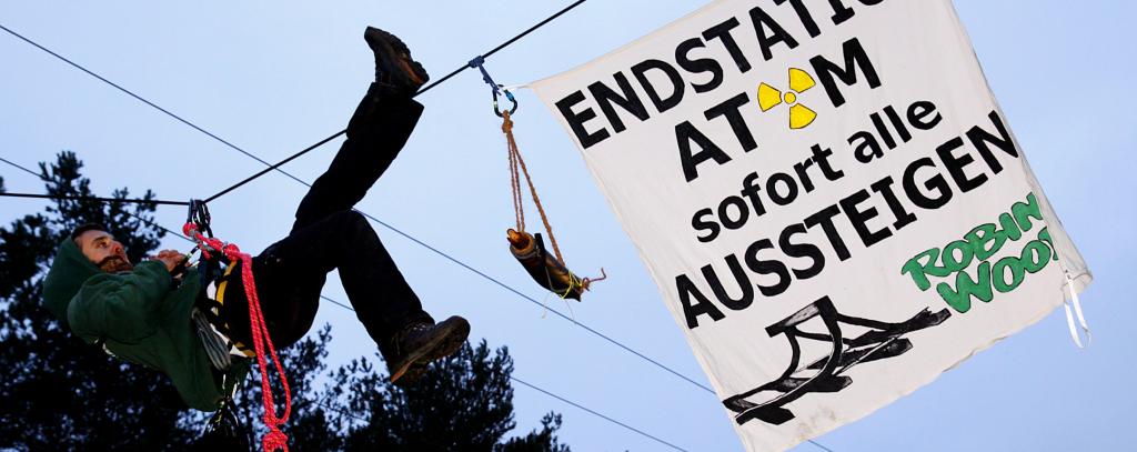 Aktivist im Seil mit Banner gegen Atomkraft
