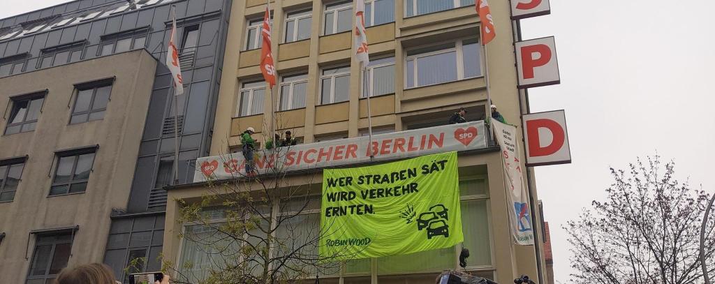 Protestaktion für mehr Tempo bei der Verkehrswende in Berlin, Kurt-Schumacher-Haus, 12.11.21 (Foto: ROBIN WOOD) Kletter-Aktivist*innen haben ein Banner am Kurt-Schumacher-Haus der SPD in Berlin befestigt. Aufschrift: "Wer Straßen sät, wird Verkehr ernten. ROBIN WOOD"