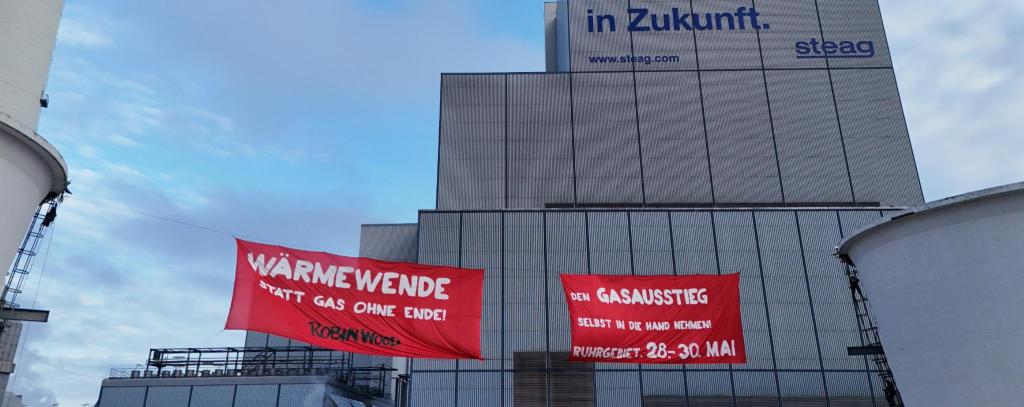 Rote Gasprotestbanner zwischen zwei Kühltürmen