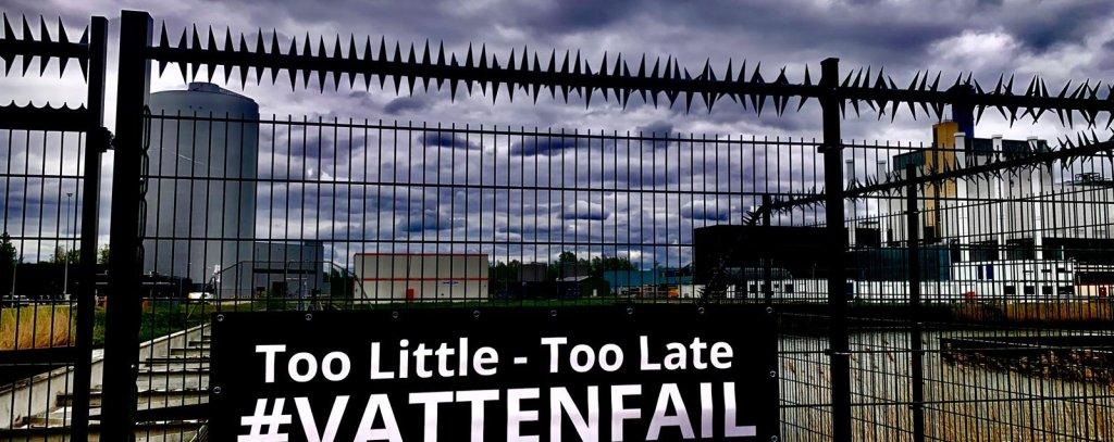 Ein Banner vor einem Kraftwerk an einem Zaun