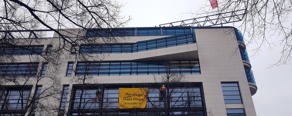 Klimaprotest an der SPD-Bundeszentrale in Berlin, 4.12.21 (Foto: ROBIN WOOD) Zwei Kletter*innen haben sich mit einem Banner vor der Fassade des Willy-Brandt-Hauses in Berlin abgeseilt. Banner-Aufschrift: Flüge statt Züge! ROBIN WOOD