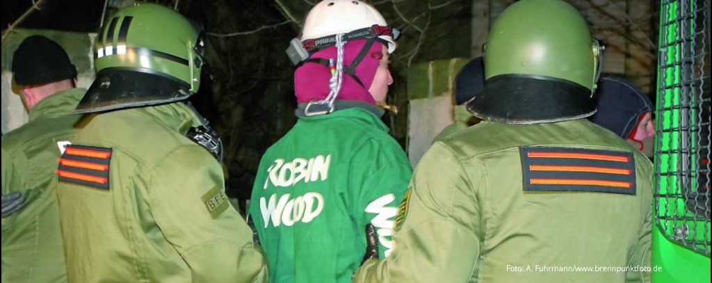 Foto: A. Fuhrmann/brennpunktfoto.de Foto Polizisten führen einen ROBIN WOOD-Aktiven ab