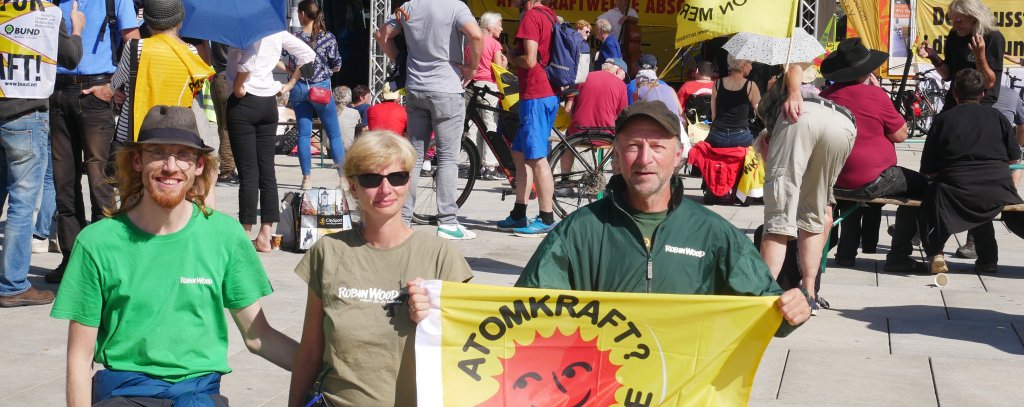 Drei Aktivist*innen mit einer Atomkraft-Nein-Danke-Flagge