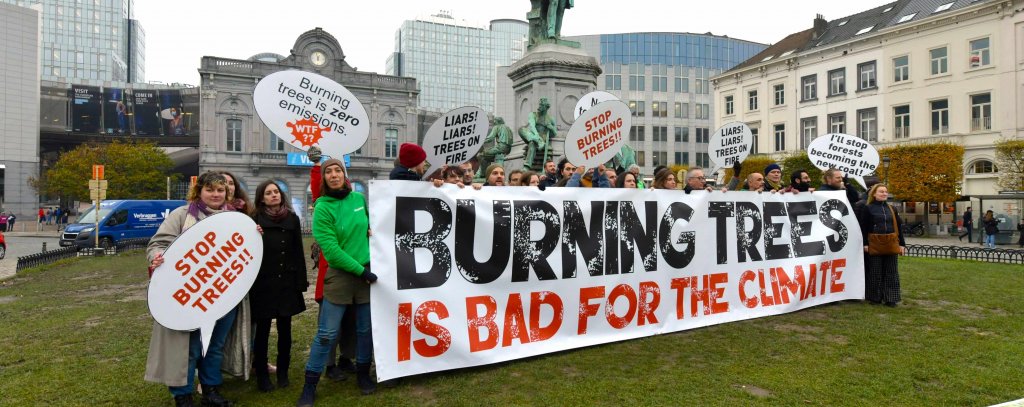 Viele Menschen mit einem Banner mit dem Spruch "Burning Trees is Bad For The Climate" auf dem Place du Luxembourg vor dem EU Parlament in Brüssel.