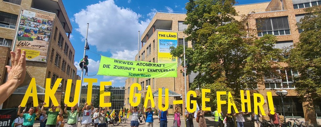 Protestkundgebung vor dem Umweltministerium in Stuttgart, Menschen halten Buchstaben hoch. Text: Akute GAU-Gefahr
