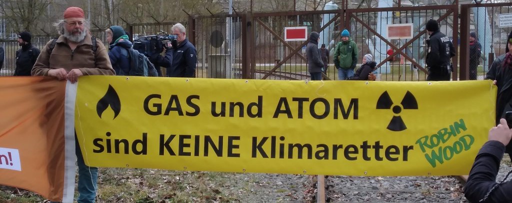 Protest für den sofortigen Atomausstieg vor dem AKW Isar-2, 4.3.2023 (Foto: ROBIN WOOD) Gelbes Protestbanner mit Aktivist*innen vor dem AKW Isar-2