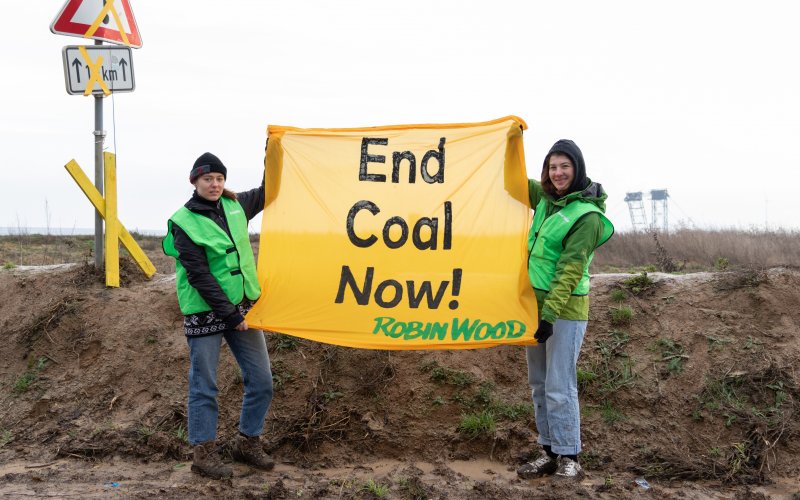 Aktionsfoto mit zwei Aktiven und Transpi "End coal now!"