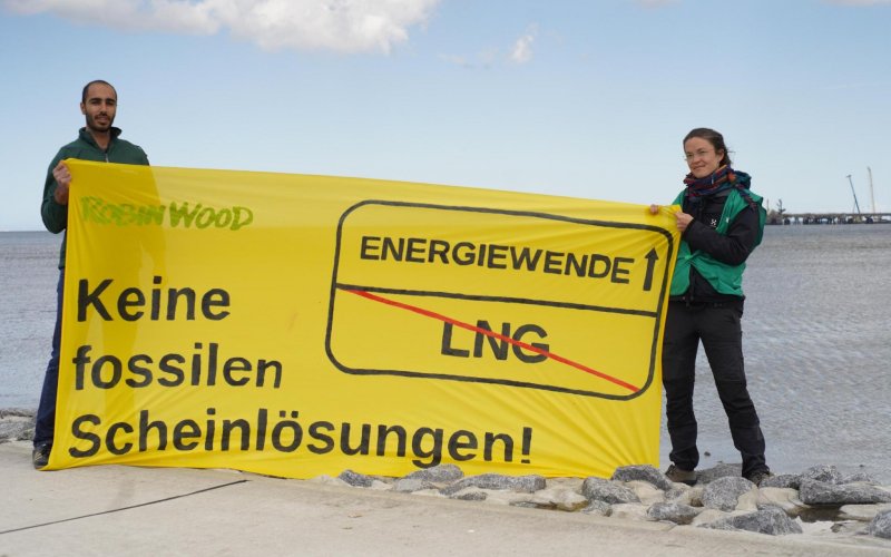 Aktivist*innen mit einem gelben Banner gegen LNG, Aufschrift: Keine fossilen Scheinlösungen