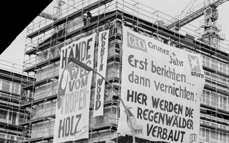 Zwei Protestbanner an der Fassade eines Gebäudes