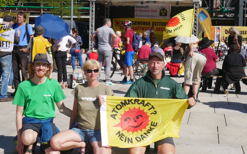 Drei Aktivist*innen mit einer Atomkraft-Nein-Danke-Flagge