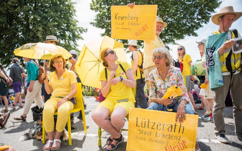 Teilnehmer*innen der symbolischen Sitzblockade 'Alle Dörfer Bleiben'