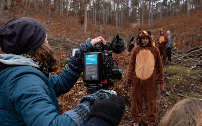Menschen in Bärenkostüm laufen auf eine Kamera zu.