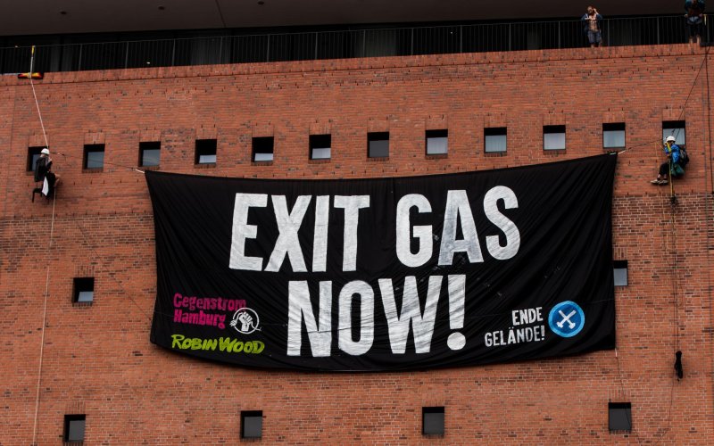 Kletter*innen vor der Fassade der Elbphilharmonie mit einem Protestbanner. Aufschrift: Exit Gas Now!