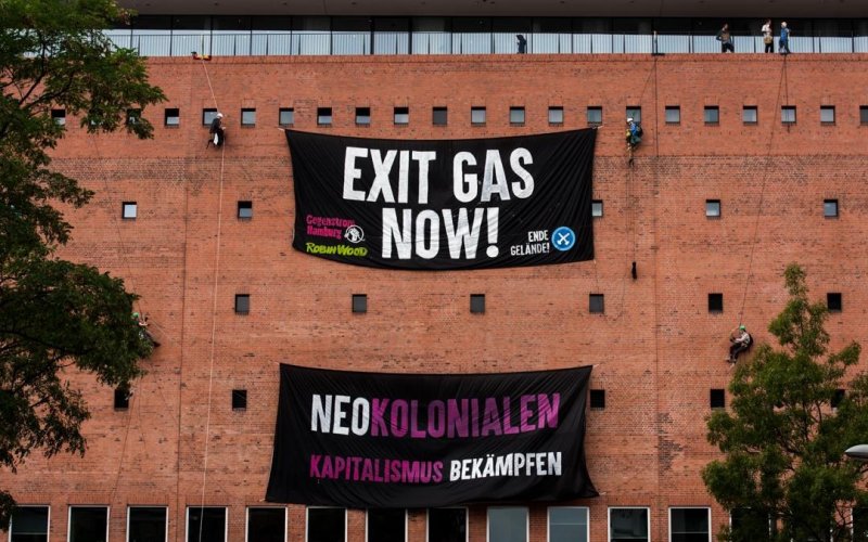 2 Protestbanner gegen Erdgas und Neokolonialismus hängen an der Elphi in HH