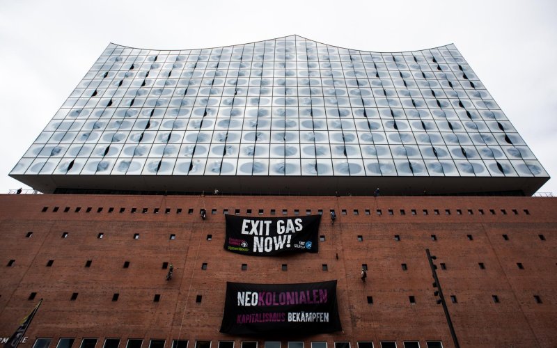 2 Protestbanner gegen Erdgas und Neokolonialismus hängen an der Elphi in HH