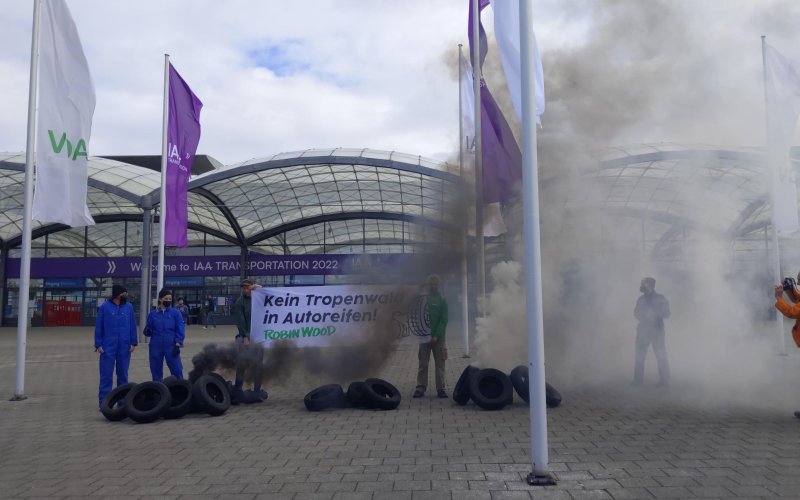 Protest mit Qualm, alten Autoreifen u. Banner gegen Tropenwaldzerstörung für Autoreifen