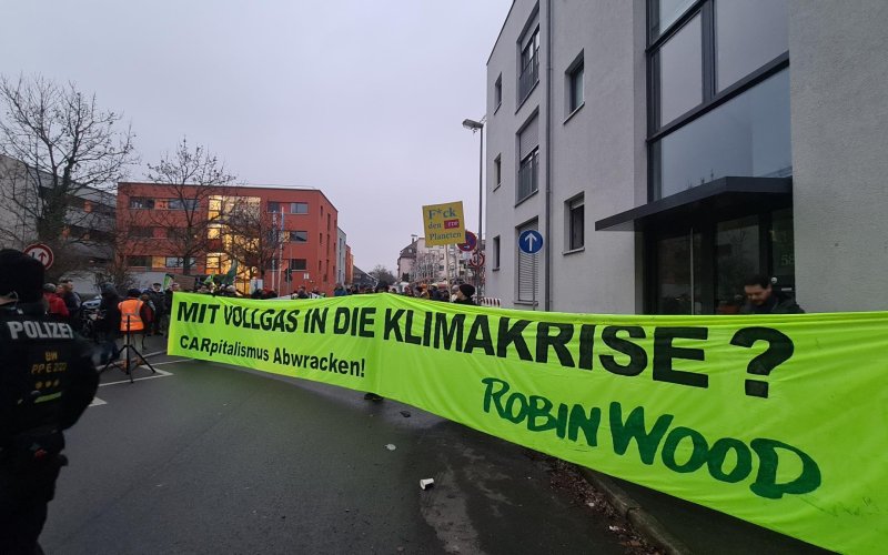 Aktive mit gelbem Protestbanner auf einer Straße