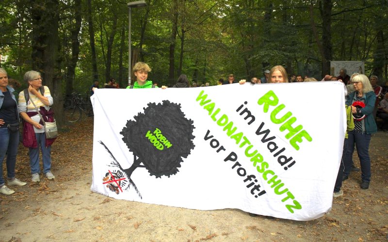 Menschen mit Banner "Ruhe im Wald! Waldnaturschutz vor Profit!"